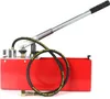 A red hydraulic pressure testing pump with a black hose and a silver handle is shown against a white background. Náhľad obrázku produktu