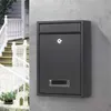 A black mailbox is mounted on a gray wall, with a white railing and stairs visible in the background. Podgląd zdjęcia produktu