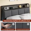 A close-up view of a dark gray upholstered headboard with a shelf above, featuring a digital clock, a charging phone, and a decorative lamp. Below the headboard, there are two smaller images showcasing the fabric texture and a hand pressing into the uphols Produktbild-Vorschau