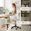 A woman is sitting on a beige ergonomic chair at a desk with a computer. Produktbild-Vorschau