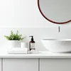 A clean and minimalist bathroom countertop with a sink, faucet, and various bathroom accessories. Produktbild-Vorschau