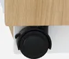A close-up view of a black caster wheel attached to the bottom of a wooden and white piece of furniture. Anteprima dell’immagine prodotto