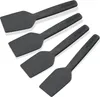Four black spatulas are arranged diagonally on a white background. Produktbild-Vorschau