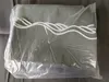 A folded piece of fabric with a wavy white pattern, enclosed in clear plastic packaging, lying on a gray surface. Produktbild-Vorschau