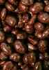 A close-up, overhead view of many chocolate-covered peanuts. Produktbild-Vorschau