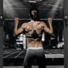 A woman is performing a pull-up exercise with a barbell in a gym. Anteprima dell’immagine prodotto