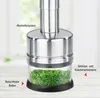 A close-up of a stainless steel herb and vegetable chopper with chopped herbs in the glass container. Anteprima dell’immagine prodotto
