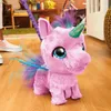 A pink plush unicorn toy with blue and purple accents is being walked by a person's legs on a wooden floor. Náhled obrázku produktu