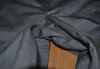 A close-up view of the seam and fabric of dark gray work pants. Podgląd zdjęcia produktu