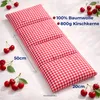 A red and white checkered cherry stone pillow is shown on a white background, surrounded by cherries and with dimensions indicated. Produktbild-Vorschau