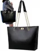 A woman is holding a black tote bag. Náhľad obrázku produktu