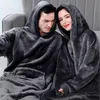 A couple wearing oversized hooded blankets. Produktbild-Vorschau