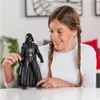 A young girl is holding a Darth Vader action figure. Anteprima dell’immagine prodotto