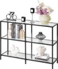 A three-tiered console table with glass shelves and a black metal frame, decorated with various items. Náhľad obrázku produktu