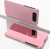 A pink smartphone case with a clear view flip cover is displayed on a white and gray surface. Produktbild-Vorschau