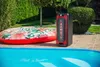 A portable speaker and an inflatable raft are placed next to a swimming pool on a tiled patio. Anteprima dell’immagine prodotto