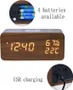 A digital alarm clock with a wood-grain finish, displaying time, humidity, and temperature. It also shows battery compartment and USB charging port. Produktbild-Vorschau