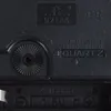Close-up of the back of a clock mechanism, showing model numbers, certifications, and battery compartment. Produktbild-Vorschau