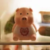 A pink piggy bank with a bib that says 'Diet Piggy' is sitting on a shelf in what appears to be a refrigerator. Podgląd zdjęcia produktu