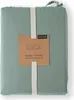 A folded mint green duvet cover is presented on a white background, secured by a cream-colored ribbon. A brown cardboard tag with product information is attached to the ribbon. Produktbild-Vorschau