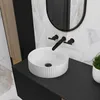 A modern bathroom sink with a black faucet and a white ceramic basin. Podgląd zdjęcia produktu