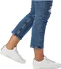 A person wearing blue jeans and white sneakers. Produktbild-Vorschau