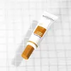 A tube of cosmetic cream is placed on a white grid surface. Produktbild-Vorschau