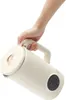 A hand holding a cream-colored electric kettle with a rose gold accent. Podgląd zdjęcia produktu