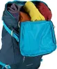 Close-up view of the top opening of a backpack, showing packed clothing items. Produktbild-Vorschau