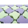 A close-up view of many small, star-shaped sponges in alternating light green and light purple colors, arranged in a grid. Produktbild-Vorschau