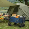 A campsite scene with a tent, camping furniture, and a folding wagon filled with camping gear. Voir les images du produit