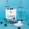A product shot of a supplement container with instructions and a glass of water in the background. Produktbild-Vorschau