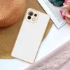A white phone case with a gold trim is placed on a straw hat, next to a book and some pink fabric. Produktbild-Vorschau