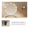 A makeup mirror with lights plugged into a wall socket, with a close-up of the power adapter in the bottom left. Podgląd zdjęcia produktu