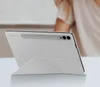 A white tablet case with a stand is shown on a table. Voir les images du produit