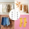 A collage of four images showing clothing items on hangers, dresses on a rack, jeans on a rack, and socks on a clothesline. Produktbild-Vorschau