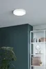 A modern bathroom scene with a ceiling light, a plant, and a shelving unit with towels and toiletries. Produktbild-Vorschau