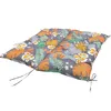 A close-up, angled view of a tufted seat cushion with a tropical leaf and flower pattern on a white background. Voir les images du produit