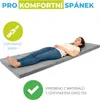 A woman is lying on a folded gray mattress. Náhled obrázku produktu