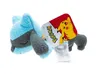 A plush toy of a Pokemon character, Riolu, lying down with its eyes closed. A tag with the Pokemon logo and Pikachu is attached to the toy. Anteprima dell’immagine prodotto