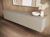 A modern living room with a wall-mounted TV lowboard, a decorative bowl, and a vase with flowers. Produktbild-Vorschau