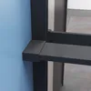 A close-up view of a black shower wall with a shelf and towel holder, attached to a blue wall. Produktbild-Vorschau