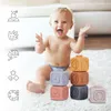 A happy baby sitting on a rug playing with stacking blocks. Voir les images du produit
