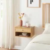 A floating nightstand with a drawer and shelf is mounted on a white wall next to a bed. Podgląd zdjęcia produktu