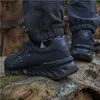A person wearing black safety shoes is standing on a wooden surface. Náhľad obrázku produktu