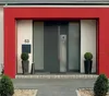 A modern front door entrance with a mailbox, plants, and a red frame. Náhled obrázku produktu