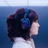 A woman wearing blue headphones with a colorful iridescent earcup. Anteprima dell’immagine prodotto
