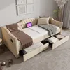 A beige upholstered daybed with tufted headboard, two blankets, a pillow, and two storage drawers pulled out, set in a bedroom. Anteprima dell’immagine prodotto