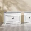 Two white shoe cabinets with gray cushions on top are shown side-by-side in a room with a light-colored wall and wooden floor. Produktbild-Vorschau