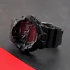A black G-Shock watch with a red digital display is shown from a side angle on a dark surface with a red stripe in the foreground. Voir les images du produit
